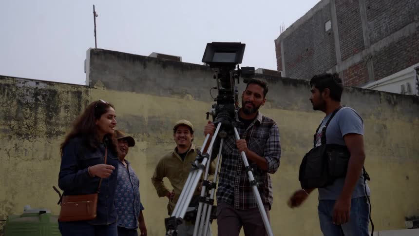 A film crew completes shooting on a street gathers their equipment and moves away