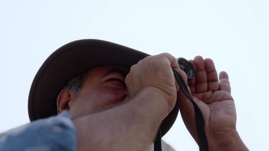 Close up of a filmmaker looking at a location through a small lens