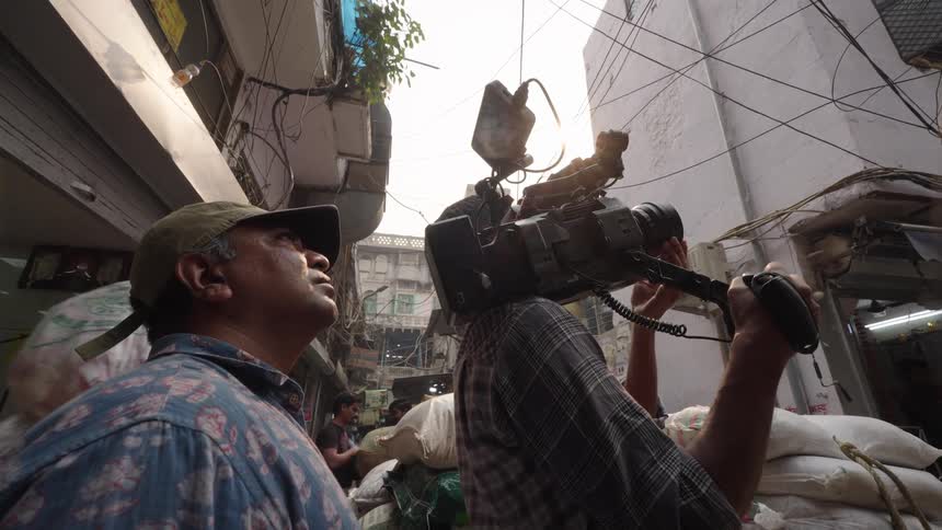 Filmmarks with professional cameras used in an outdoor environment surrounded by shops and pedestrians