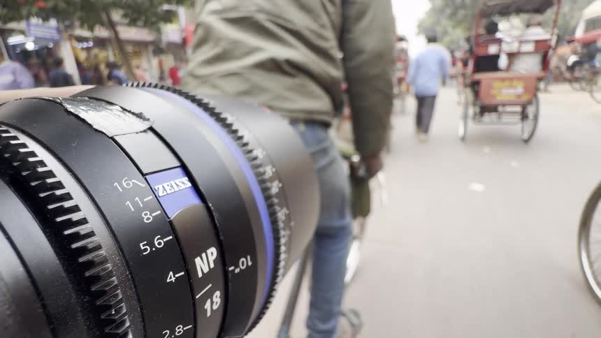 A close up of a camera lens capturing the bustling traffic on the streets of delhi