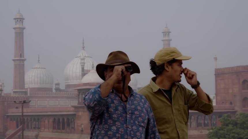 A pair of filmmakers scouting for locations in front of an historical building in dehli