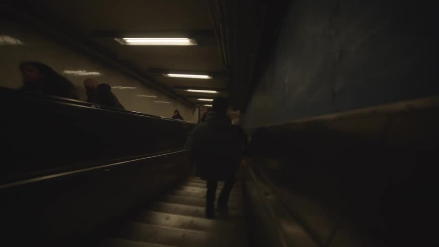 The person is running down a set of stairs and beside them is another set of stairs with people going up