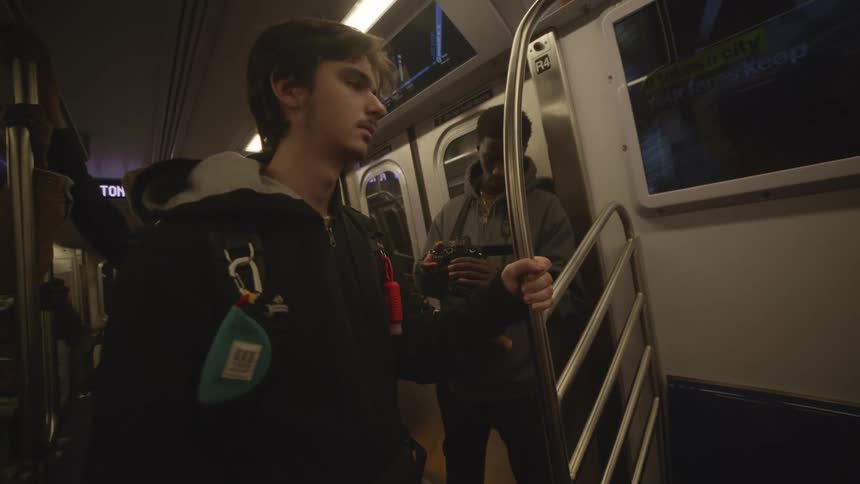 Two young people wearing thick jackets ride the subway