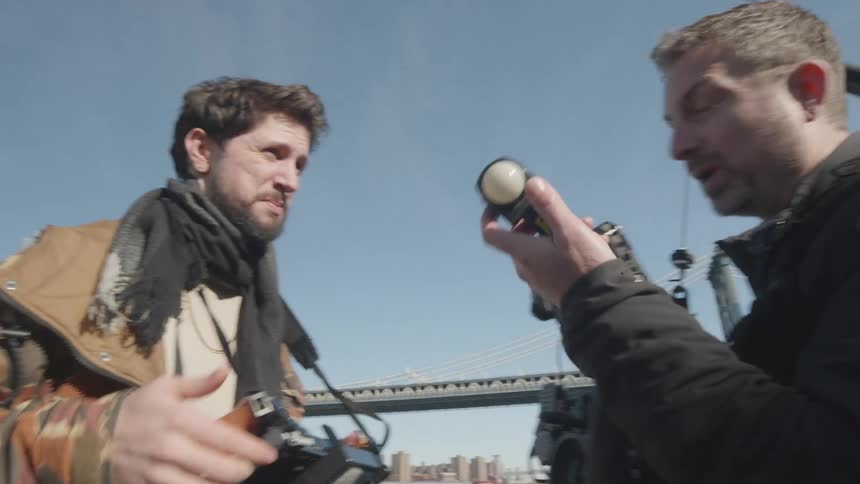 Two men talk and look at cameras
