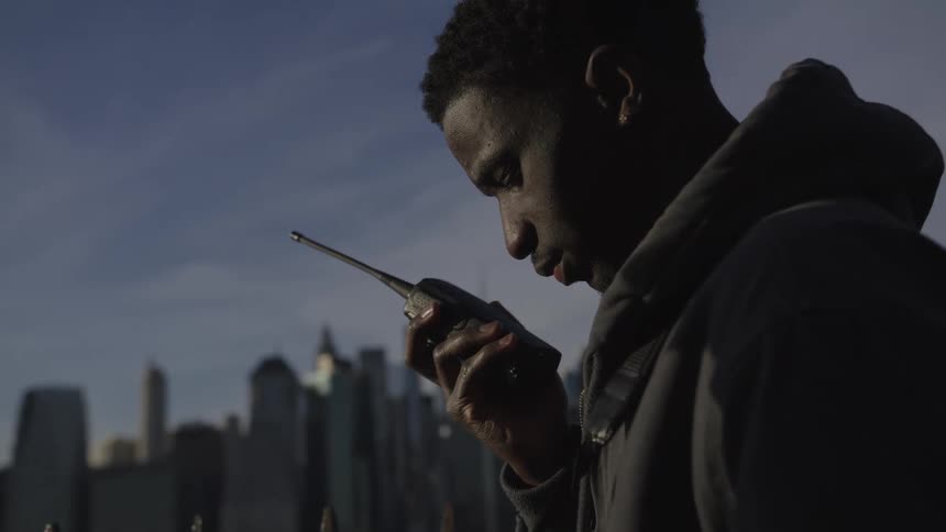 Man talks on the phone while looking at the city in the background with the clear urban sky