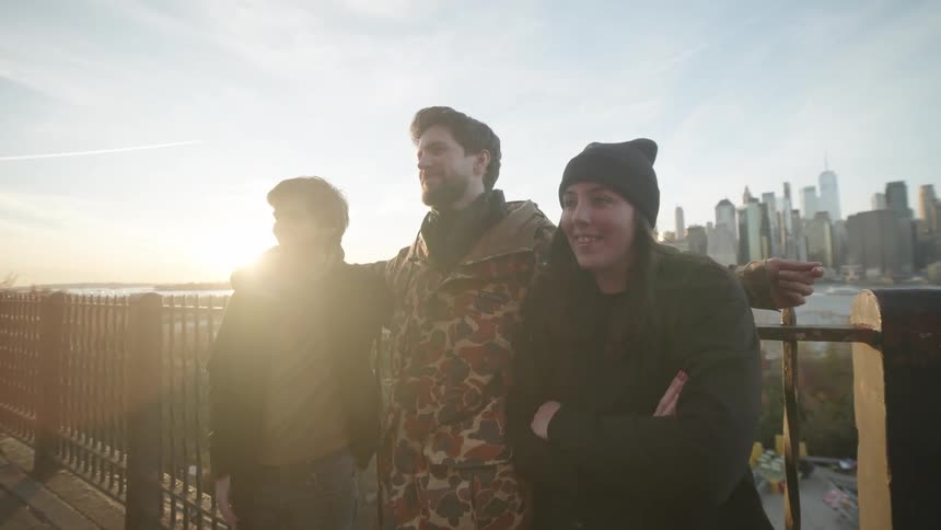 People are smiling in front of the city