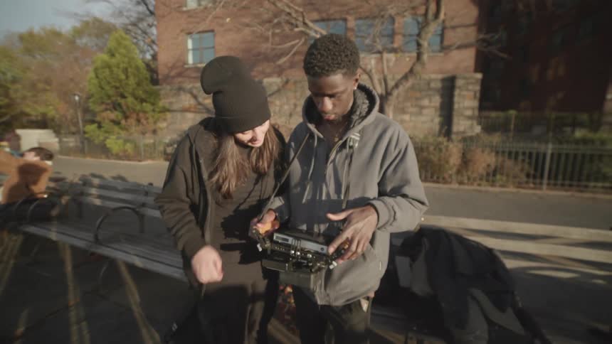 A man and woman are looking at footage on a camera