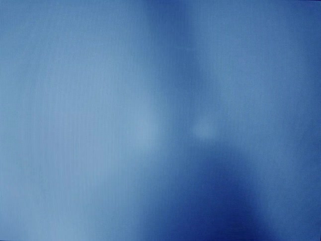 Blurry silhouette of people standing behind a plastic curtain under blue lights