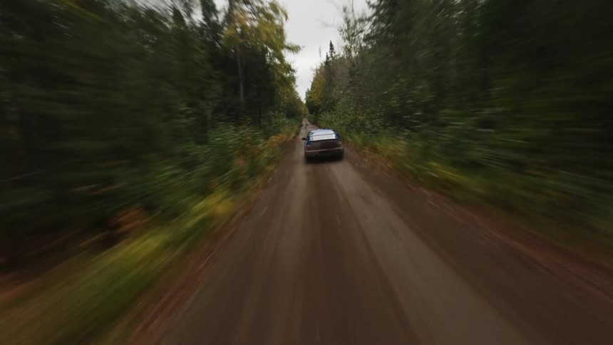 A car is racing through the mud on the trail