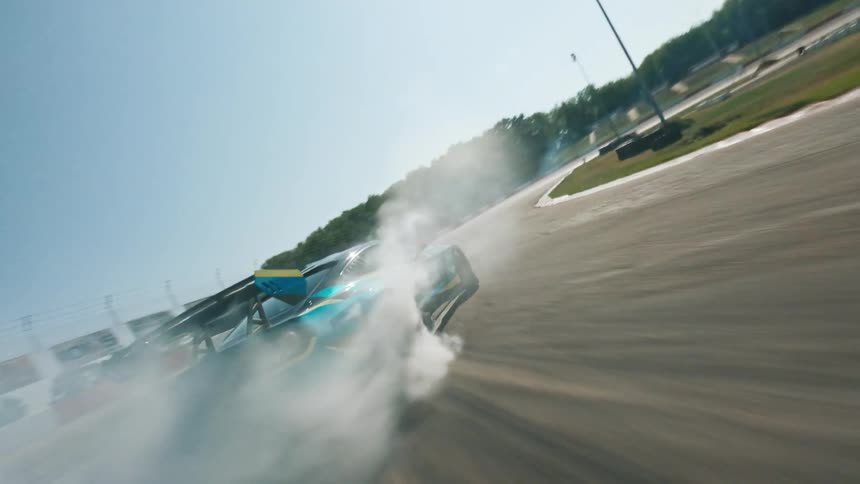 Race car creates smoke while speeding around a racetrack on a sunny day
