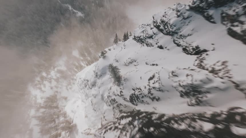 Aerial landscape of a snowy mountain valley with a coniferous forest