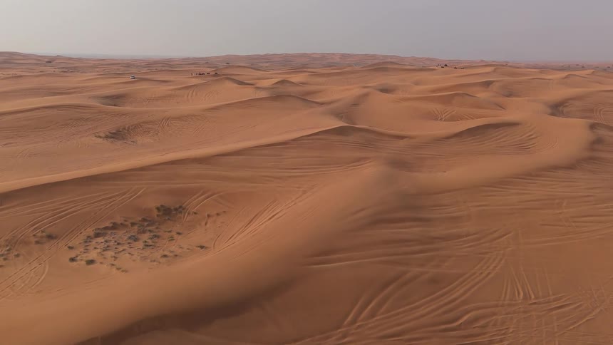 Large sand dunes cover a desert