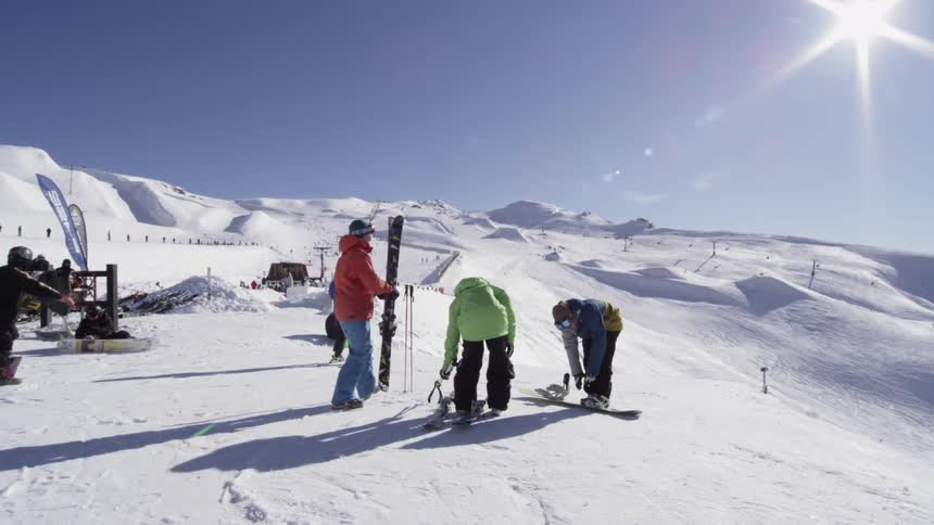 Group of snowboarders preparing to go down a hill