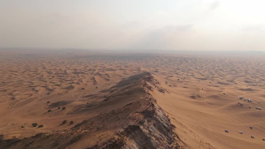 Aerial view of a desert and vehicles moving around