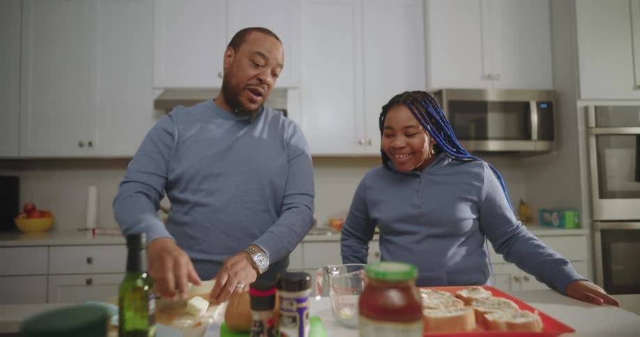 Father and daughter in the kitchen happily preparing food