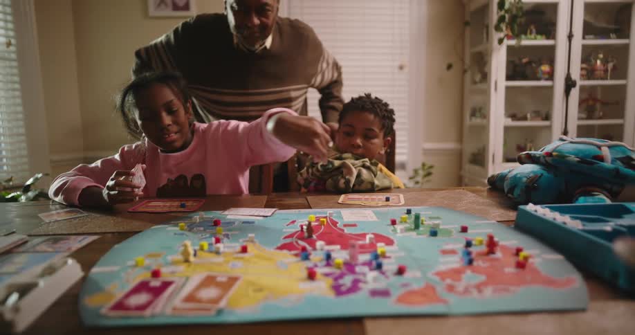 A family is sitting at a table playing a board game