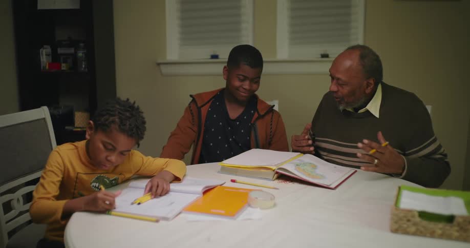 A grandfather is helping his grandsons study