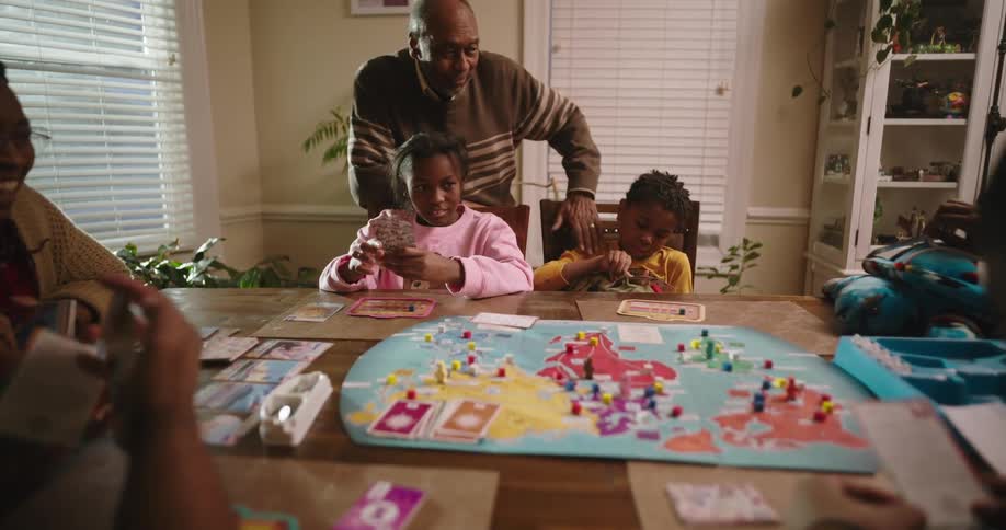 A family gathered around a table playing a board game at home