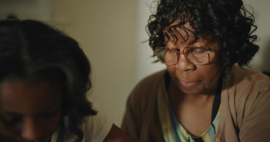 A grandmother is helping her granddaughter with homework