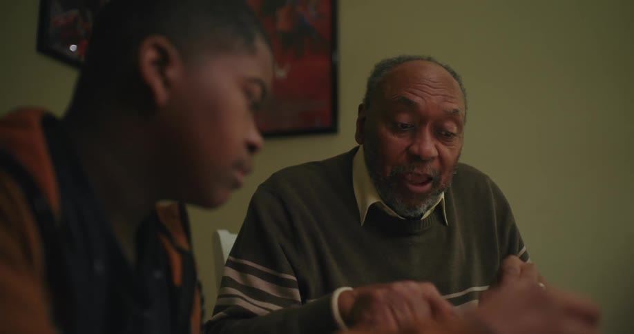 Grandfather talking or teaching something to his grandson
