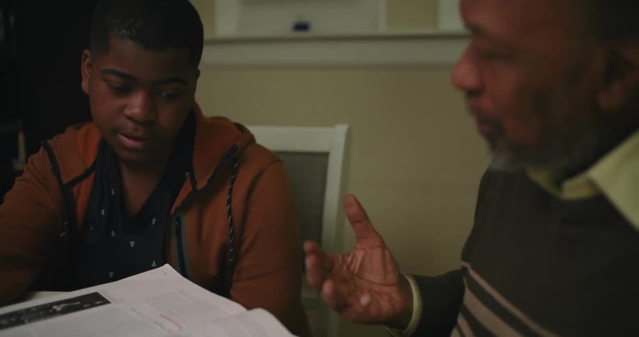 A teenager is listening to his grandfather help him study