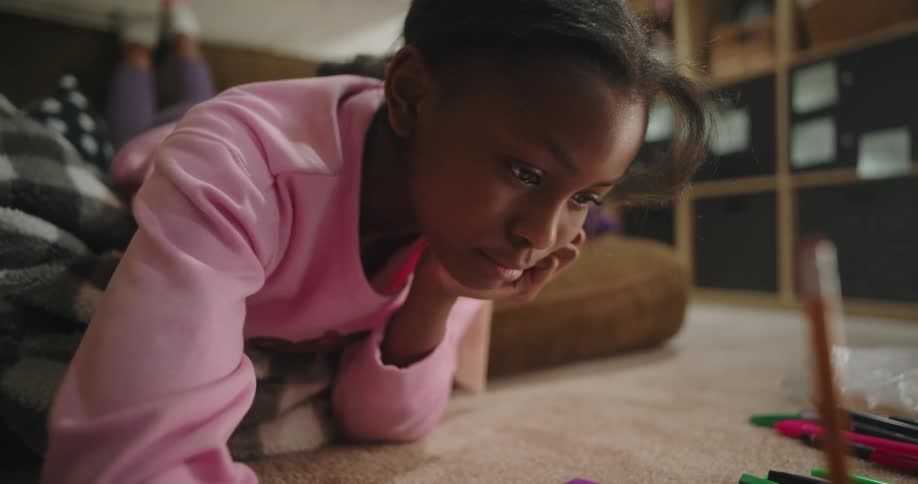 A girl lying on the floor writing
