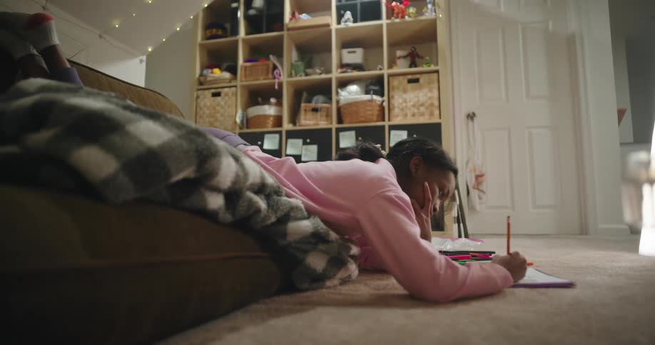 A girl is doing homework on the couch