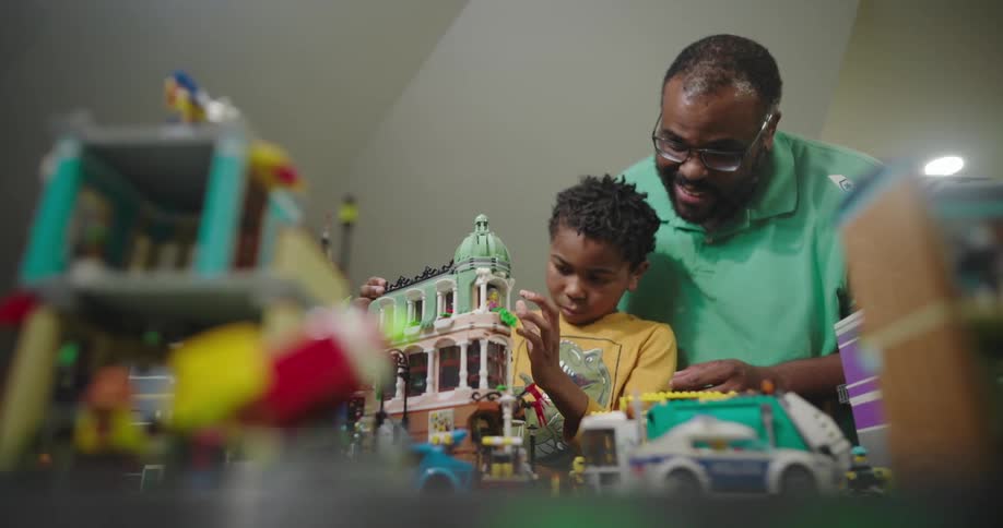 Father and son playing with colorful toys in a room at home