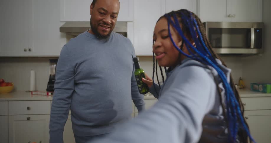 A father and daughter are cooking in the kitchen