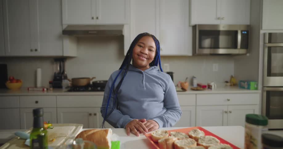 A teenager is smiling by a tray of food