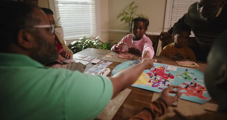 A family move the pieces on the board game