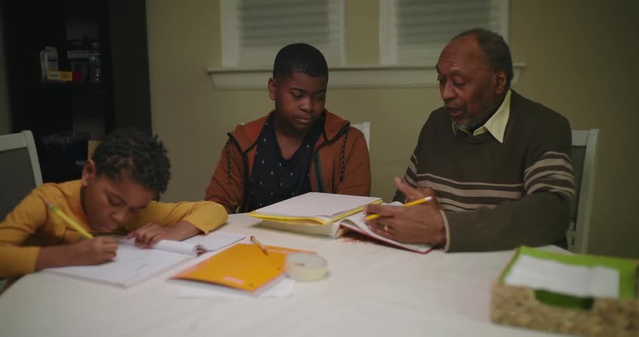 An adult helping two children with homework at home