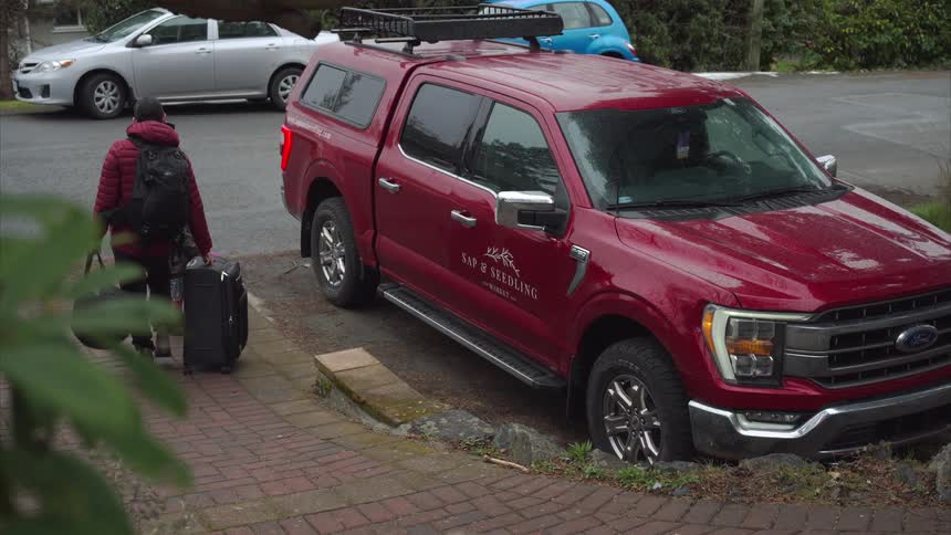 A father and daughter bring their suitcases to the car
