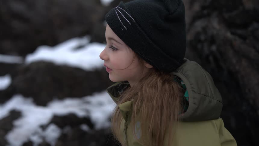 A girl is smiling on the rocks