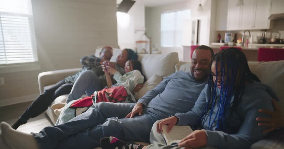 Happy family gathered together and sitting on the sofa in the living room
