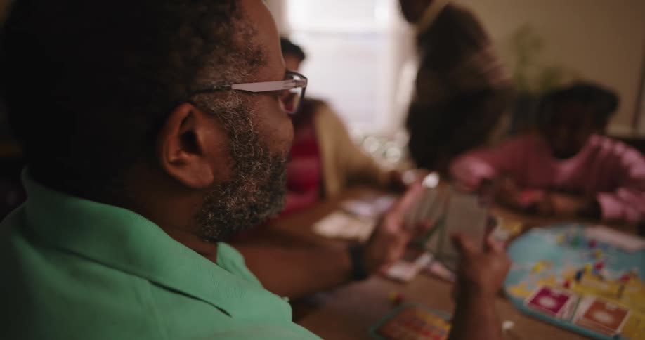 Family gathered at a table playing cards