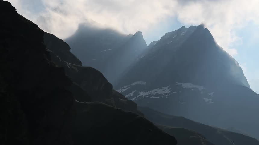 Sunlight shining through clouds over mountains