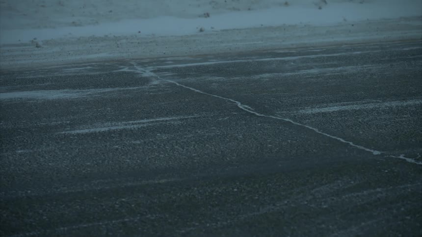 Vehicle is driving on an empty road in the winter