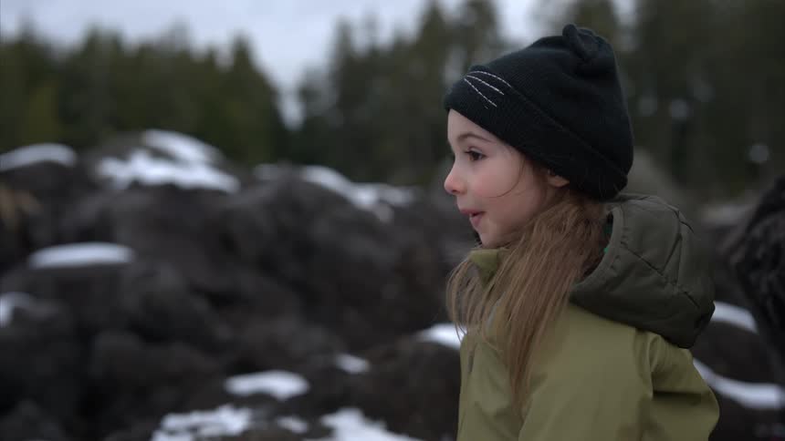 A girl is outside in the snow