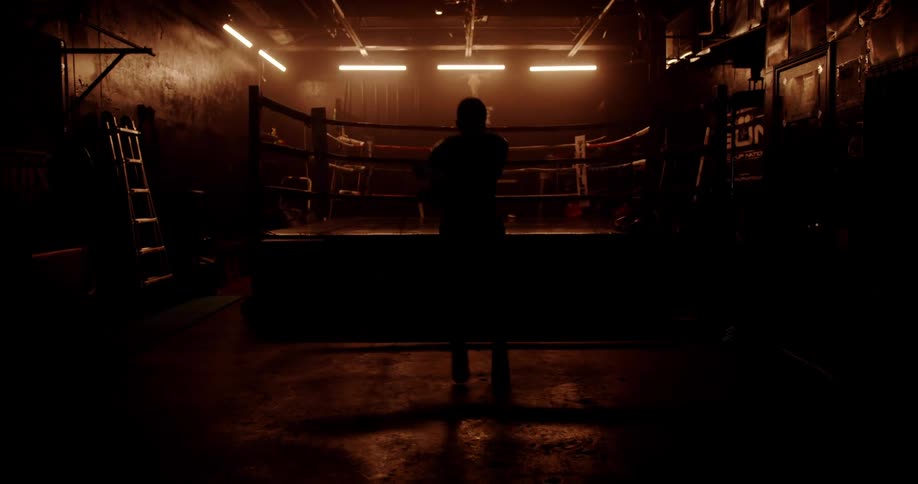 A man is jumping with a rope in a boxing gym