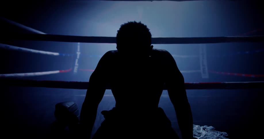 Silhouette of a boxer sitting in a ring with lowlights