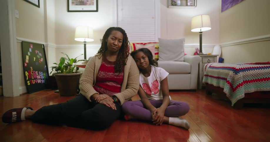 A mother and daughter sitting on the floor in a living room