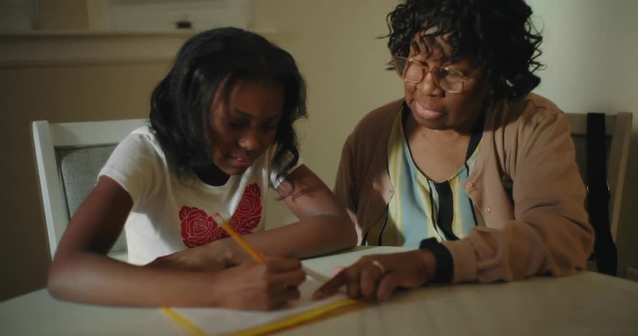 A mother helps her daughter with homework at home