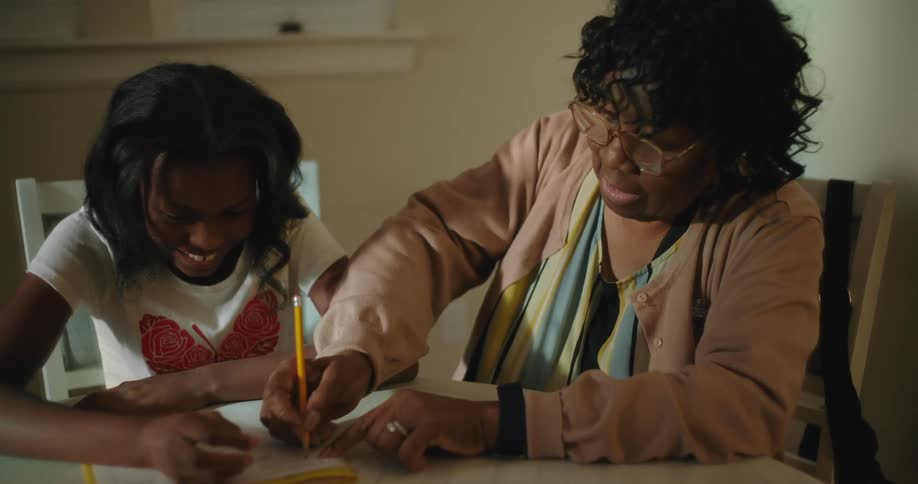 A grandmother is helping her granddaughter with homework