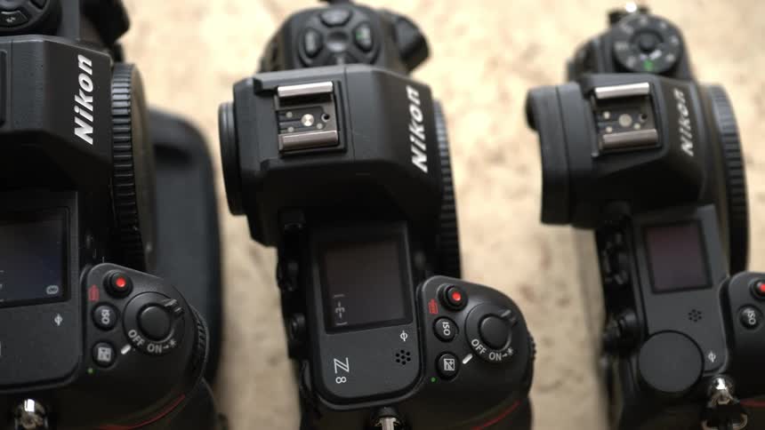 Three cameras are placed in a row on a table