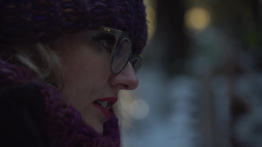 Woman talking to someone while standing outside in cold weather