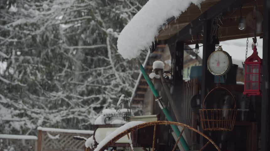 Snow falling and accumulating on porch in winter