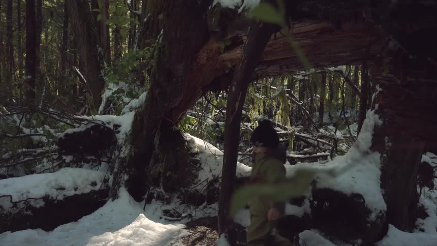 A man is filming two people hiking in the woods
