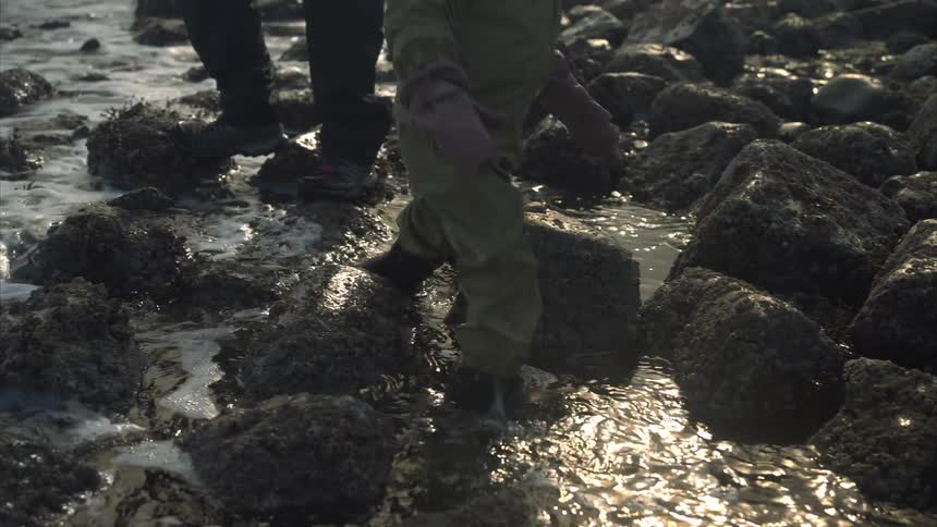 Child running among rocks in the ocean