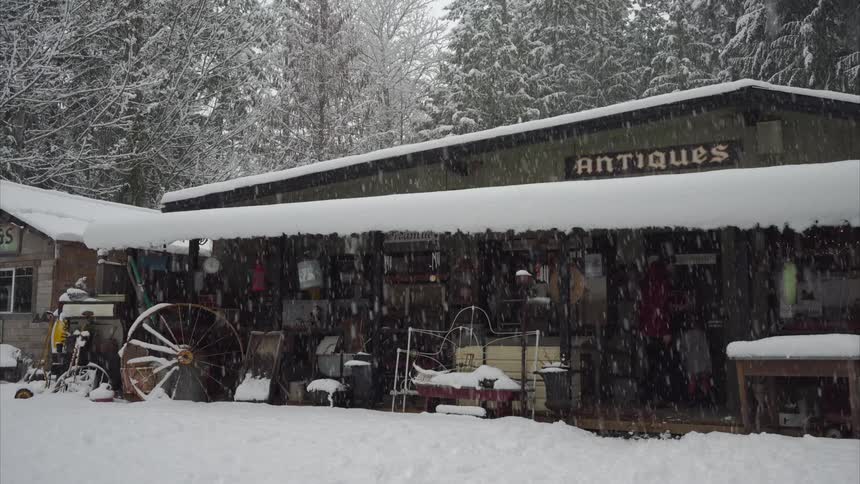 A little girl and her dad head to the door of a business in the snow